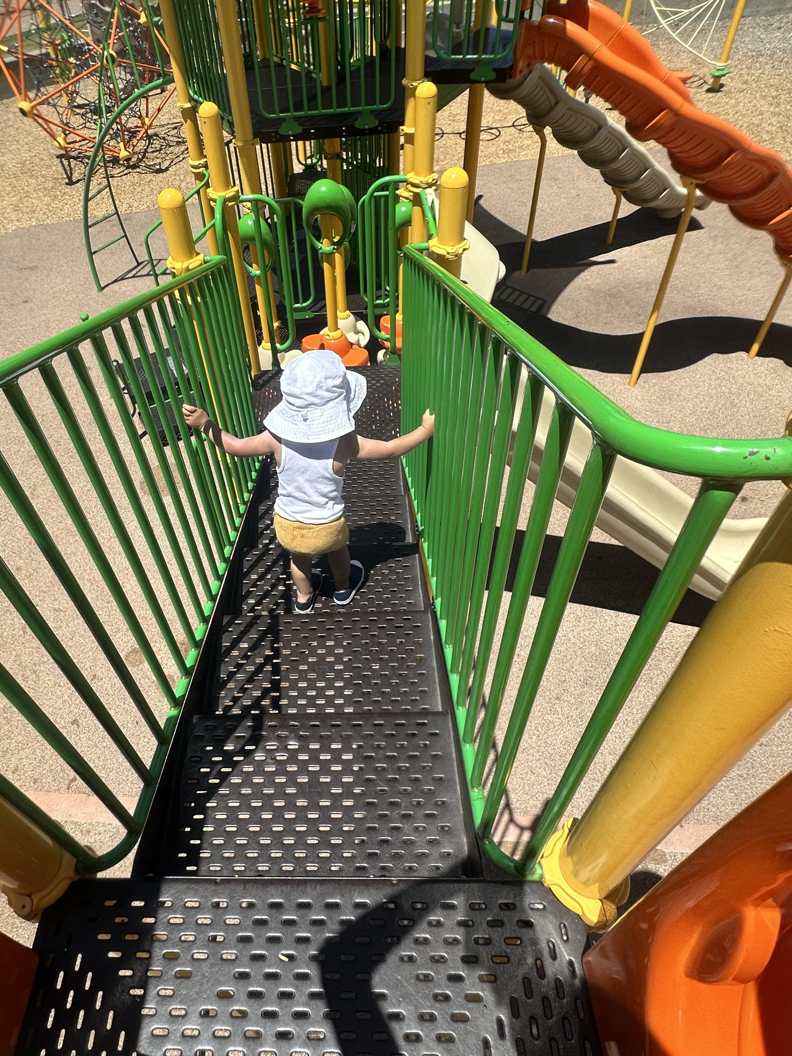 A toddler exploring the playground on a sunny day