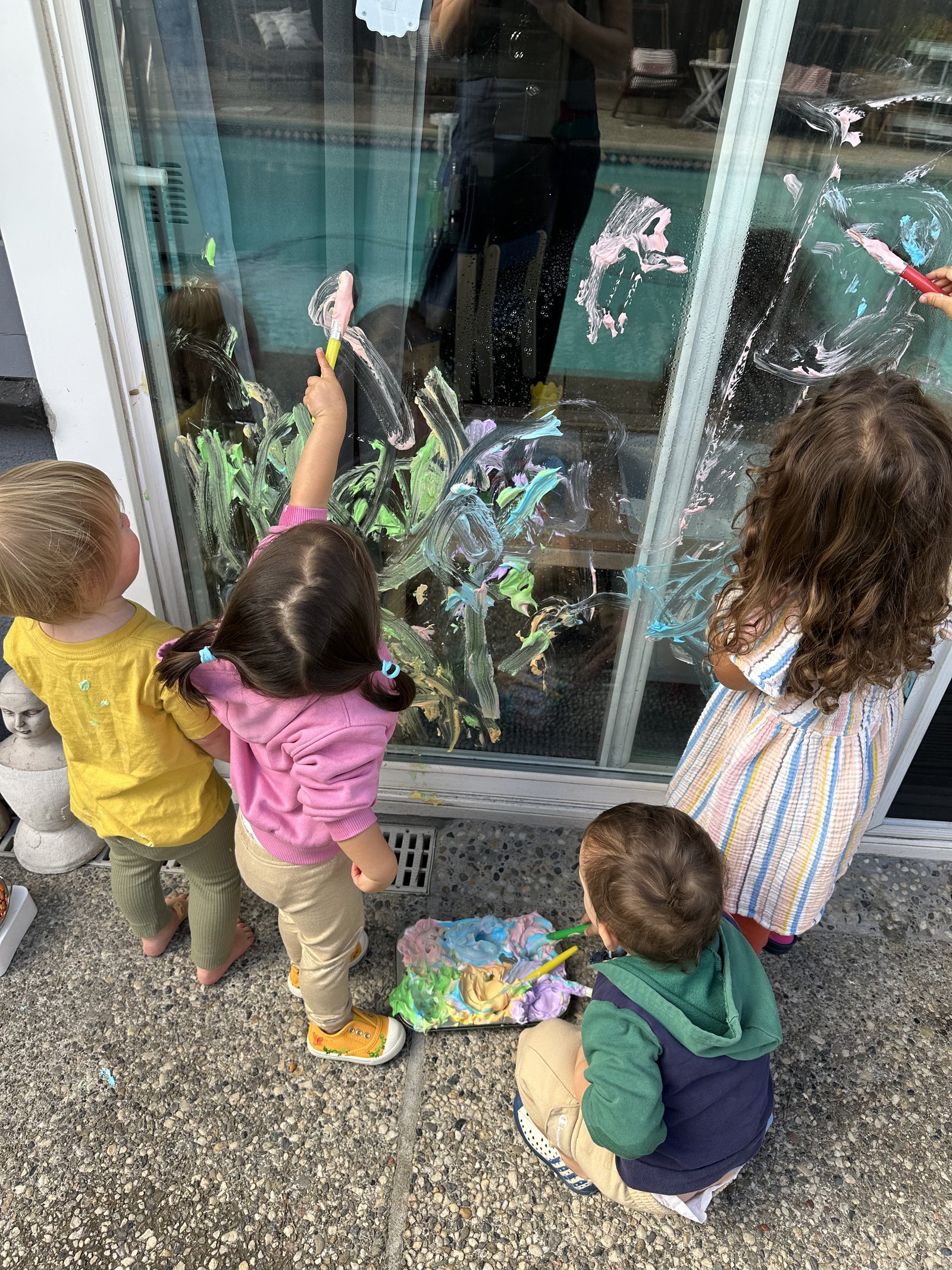 Children's brushstrokes covering a window in color